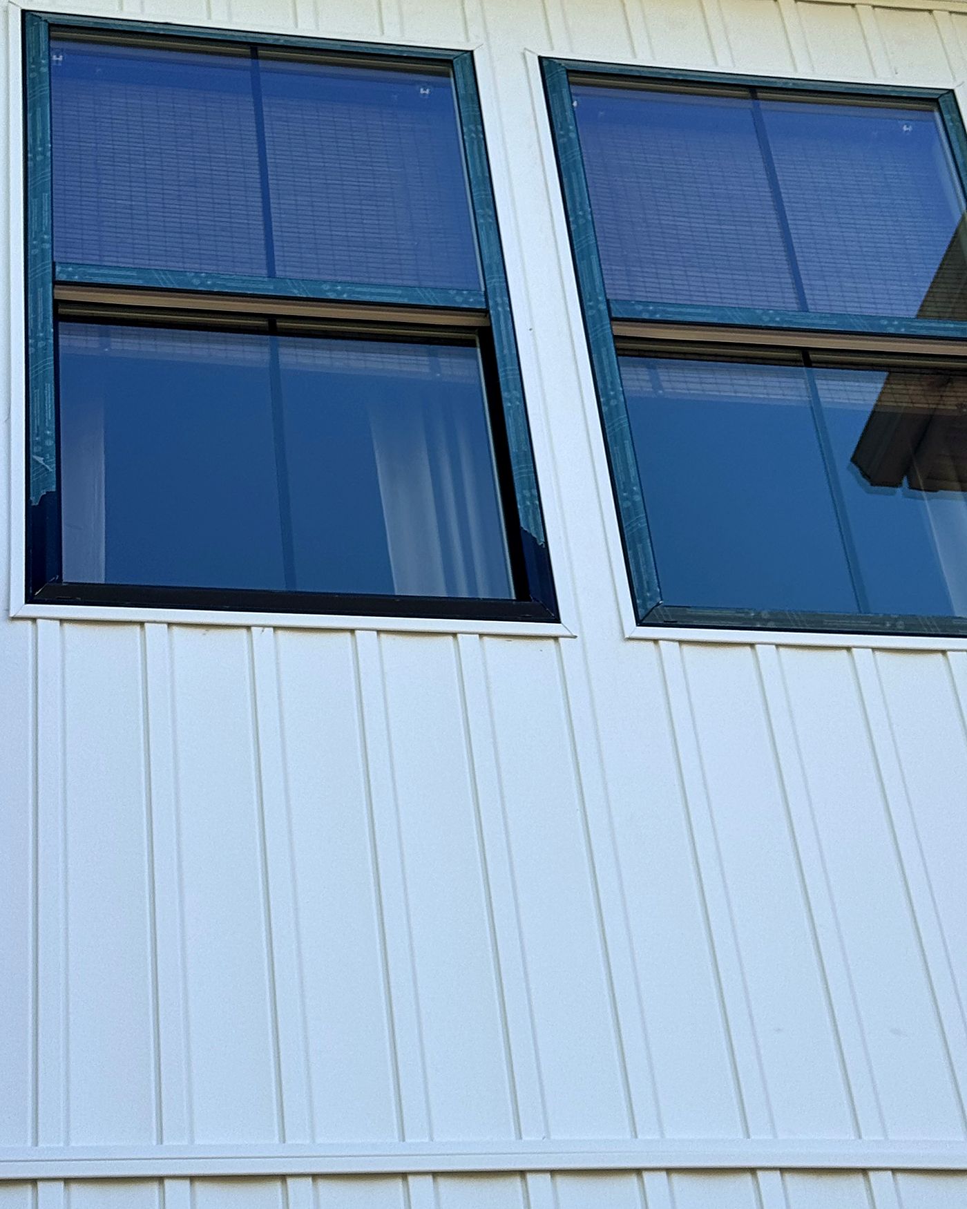 Streak-free residential windows on white board-and-batten siding